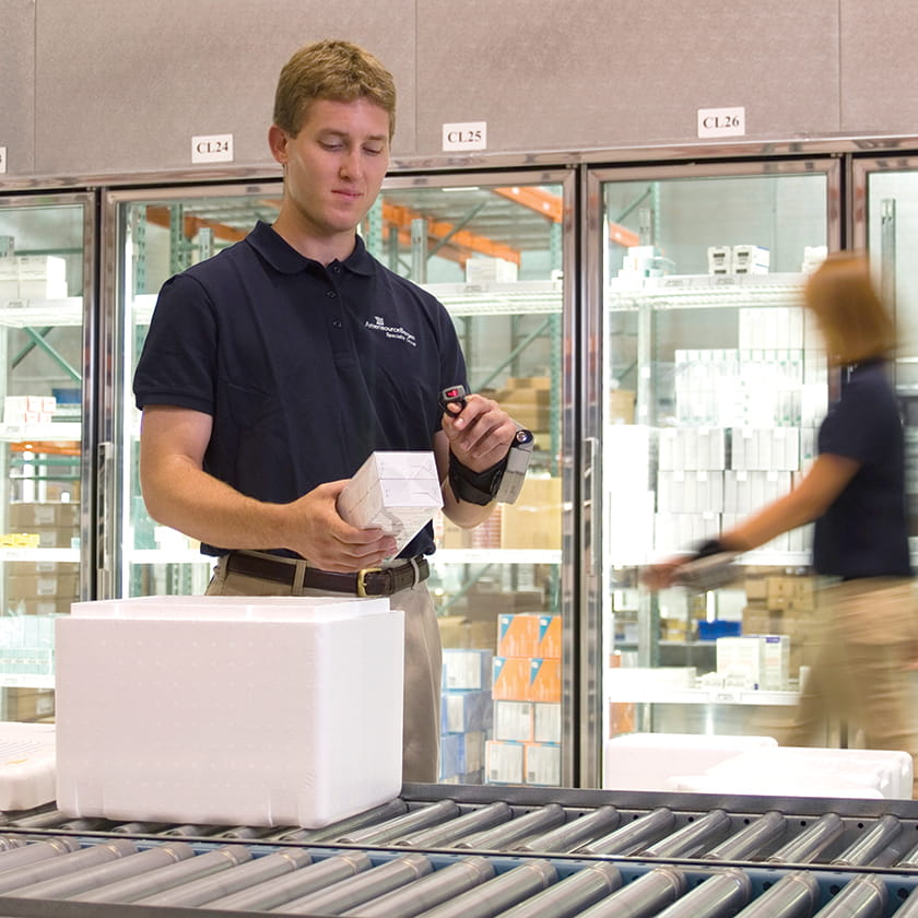 Man scanning a cooler on a conveyor belt
